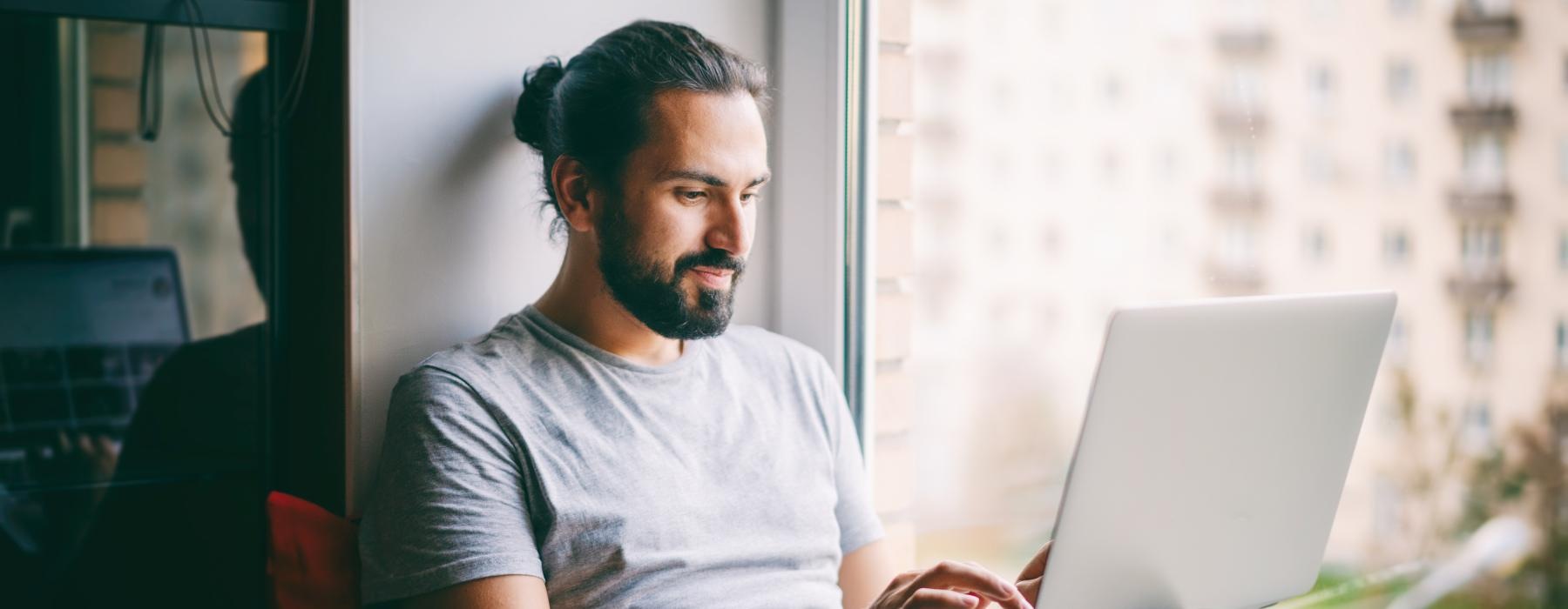 a man sitting on a couch using a laptop